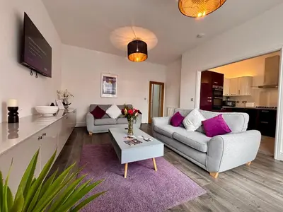 a living room with two couches and a table at Franks Apt 2 - Outdoor Balconies - Sleeps 8 in Blackpool