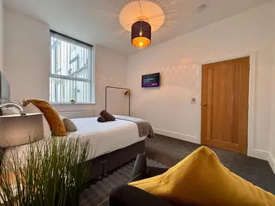 a bedroom with a bed and a tv on a wall at Franks Apt 2 - Outdoor Balconies - Sleeps 8 in Blackpool