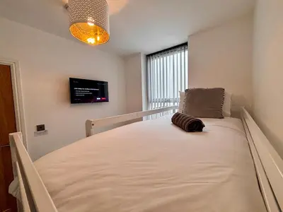 a large bed in a room with a window at Franks Apt 2 - Outdoor Balconies - Sleeps 8 in Blackpool