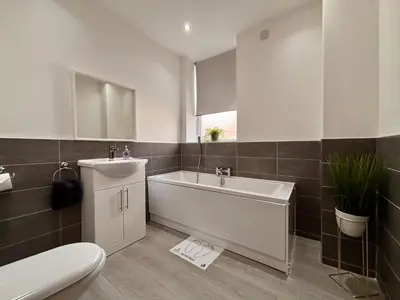 a bathroom with a tub and a sink and a toilet at Franks Apt 2 - Outdoor Balconies - Sleeps 8 in Blackpool