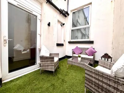 a patio with chairs and a table and a window at Franks Apt 2 - Outdoor Balconies - Sleeps 8 in Blackpool
