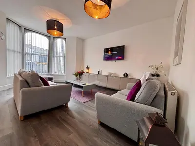 a living room with two couches and a tv at Franks Apt 2 - Outdoor Balconies - Sleeps 8 in Blackpool
