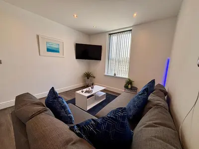 a living room with a couch and a tv at Franks Apt 3 - Sleeps 4 in Blackpool