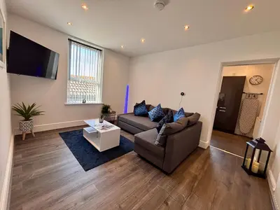 a living room with a couch and a tv at Franks Apt 3 - Sleeps 4 in Blackpool