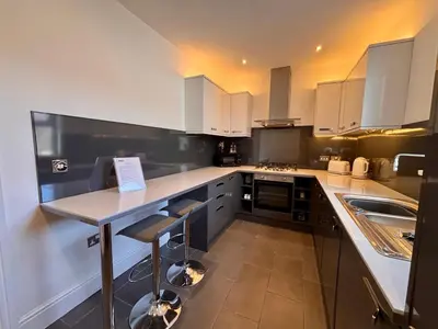 a kitchen with white cabinets and a counter with a sink at Franks Apt 3 - Sleeps 4 in Blackpool
