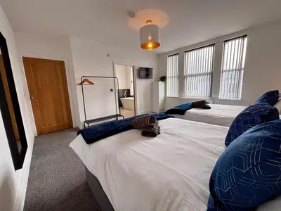 a bedroom with two beds with blue pillows on them at Franks Apt 4 - Roof Terrace - Sleeps 6 in Blackpool