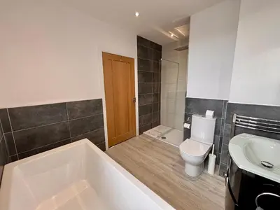 a bathroom with a tub and a toilet and a sink at Franks Apt 4 - Roof Terrace - Sleeps 6 in Blackpool