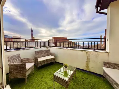 a balcony with chairs and tables and a view of the city at Franks Apt 4 - Roof Terrace - Sleeps 6 in Blackpool