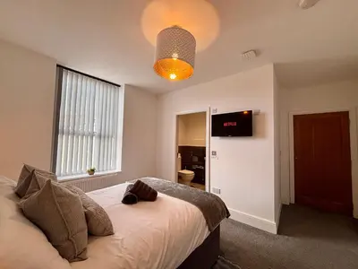 a bedroom with a bed and a tv on the wall at Franks Apt 4 - Roof Terrace - Sleeps 6 in Blackpool