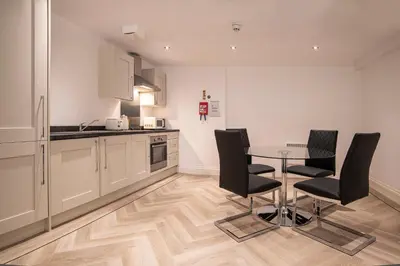 a kitchen with a table and black chairs at The Castle Collection - 5 Union Court in Liverpool