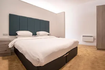a bedroom with a large bed with a black headboard at The Castle Collection - 5 Union Court in Liverpool