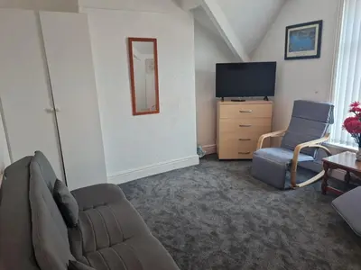 a living room with a couch and a tv at Lawnswood Apartments in Blackpool
