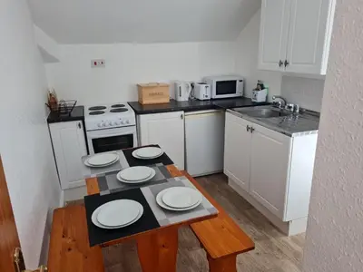 a kitchen with a table with white plates on it at Lawnswood Apartments in Blackpool