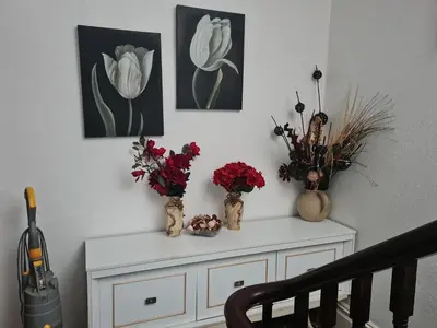 a white cabinet with three vases with flowers on it at Lawnswood Apartments in Blackpool