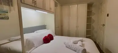 a bedroom with a white bed with red pillows at Lawnswood Apartments in Blackpool