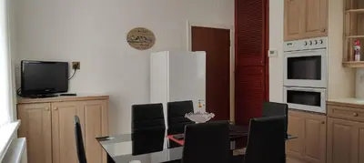 a kitchen with a table and chairs and a television at Lawnswood Apartments in Blackpool