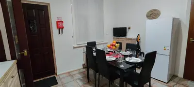 a dining room table with black chairs and a kitchen at Lawnswood Apartments in Blackpool