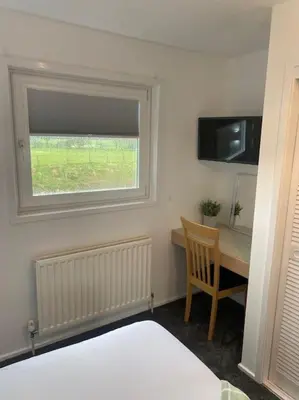 a bedroom with a desk and a window and a bed at Hideaway Lodge in Carnforth
