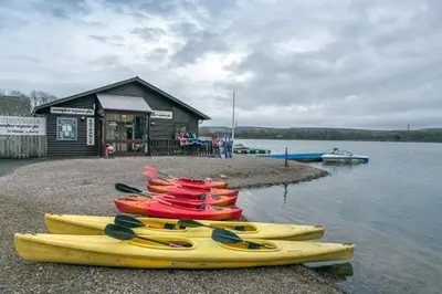 a group of kayaks lined up on the shore at Hideaway Lodge in Carnforth
