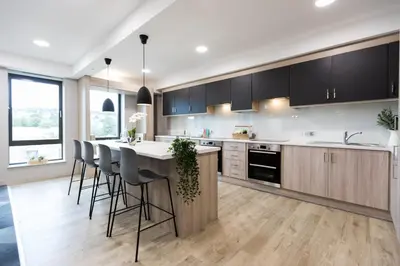 a kitchen with a large island with bar stools at For Students Aparto Caton Court Lancaster in Lancaster