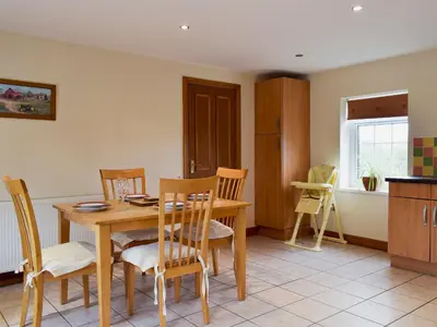 a kitchen and dining room with a wooden table and chairs at West Boundary Farm Cottage 1 in Pilling