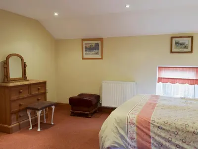 a bedroom with a bed and a dresser and a mirror at West Boundary Farm Cottage 1 in Pilling