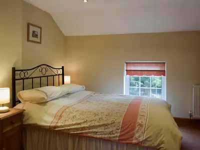 a bedroom with a large bed and a window at West Boundary Farm Cottage 1 in Pilling