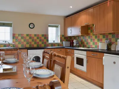 a kitchen with a wooden table with chairs and a dining room at West Boundary Farm Cottage 2 in Pilling