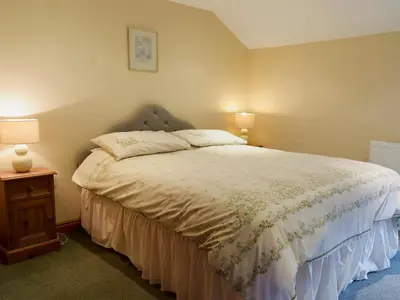 a bedroom with a bed and two lamps on a table at West Boundary Farm Cottage 2 in Pilling