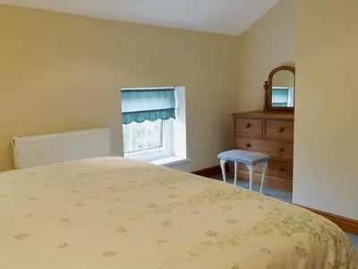 a bedroom with a bed and a dresser and a window at West Boundary Farm Cottage 2 in Pilling