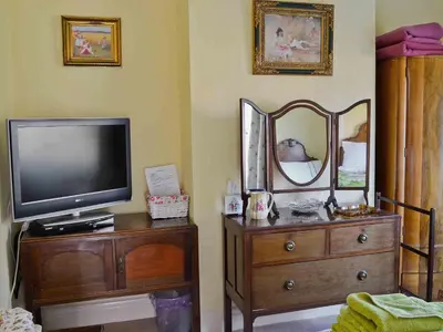 a tv and a dresser with a mirror and a television at Ivy House in Saint Annes on the Sea