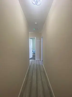 an empty hallway with a white wall and a ceiling at Jackson Holiday Apartments in Blackpool