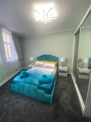 a bedroom with a large blue bed in a room at Jackson Holiday Apartments in Blackpool
