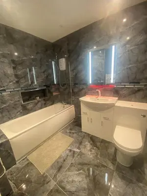 a bathroom with a tub and a toilet and a sink at Jackson Holiday Apartments in Blackpool