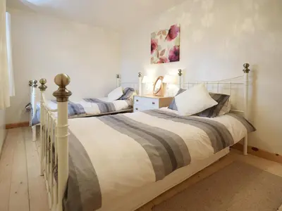 two twin beds in a room with white walls at The Barn - 27977 in Whalley