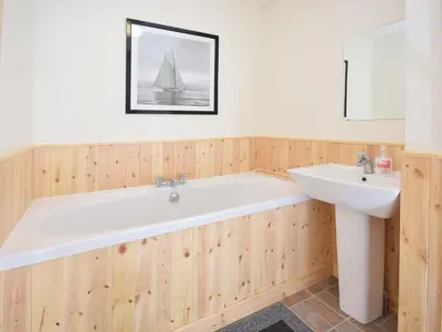 a bathroom with a bath tub and a sink at The Barn - 27977 in Whalley