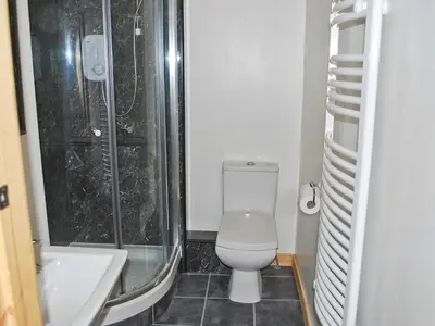 a bathroom with a toilet and a shower and a sink at The Barn - 27977 in Whalley