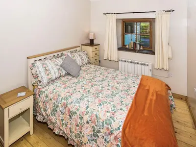 a bedroom with a bed and a window at Bramble Cottage - 27978 in Whalley