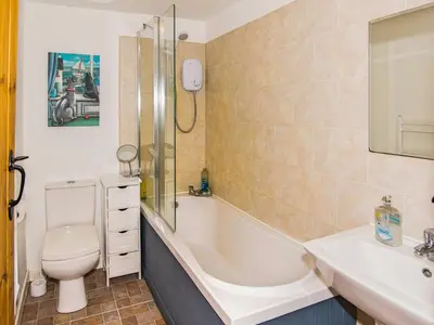 a bathroom with a tub and a toilet and a sink at Bramble Cottage - 27978 in Whalley