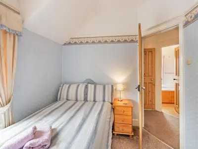a small bedroom with a bed and a night stand at 15 Elms Road in Bare