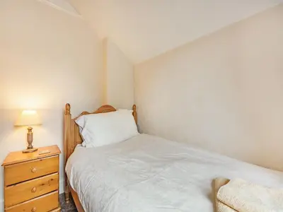 a small bedroom with a bed and a night stand at 15 Elms Road in Bare