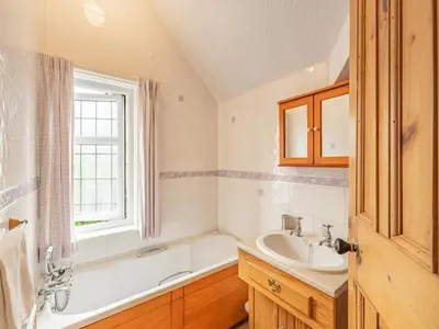 a bathroom with a tub and a sink and a bath tubermottermott at 15 Elms Road in Bare