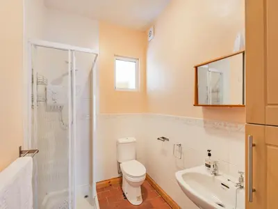a bathroom with a toilet and a sink and a shower at 15 Elms Road in Bare
