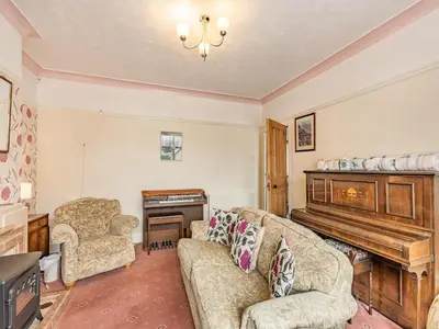 a living room with a couch and a piano at 15 Elms Road in Bare