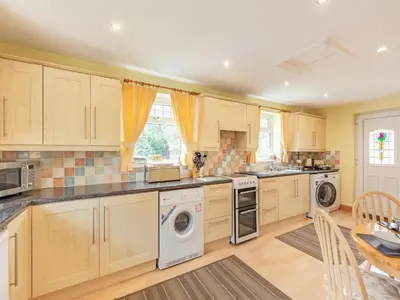 a large kitchen with wooden cabinets and appliances at 15 Elms Road in Bare