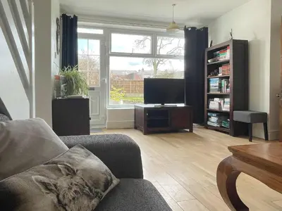 a living room with a couch and a flat screen tv at The Cottage At Stanley Villa in Southport
