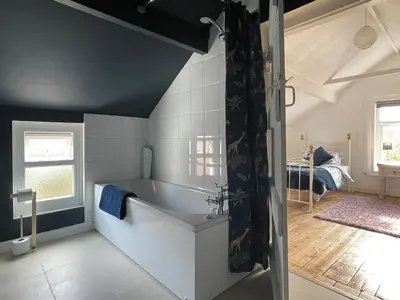 a bathroom with a bath tub in a room at The Cottage At Stanley Villa in Southport
