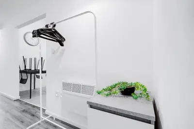 a white room with a bench with a plant at Beautiful Apartment una - free public parking in Litherland