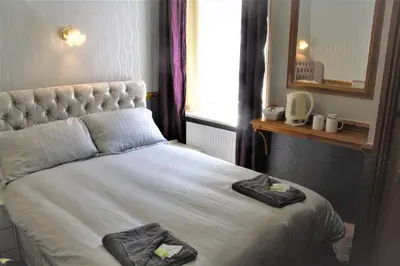 a bedroom with a bed with two towels on it at Pine Lodge Hotel in Blackpool