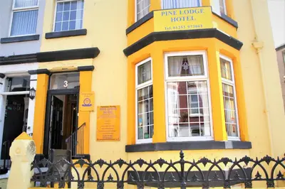 a yellow building with a sign that reads time i wonder hotel at Pine Lodge Hotel in Blackpool